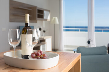 vacation room with sea view and table with bottle of wine and glasses.