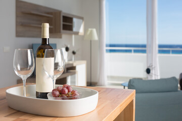 vacation room with sea view and table with bottle of wine and glasses.