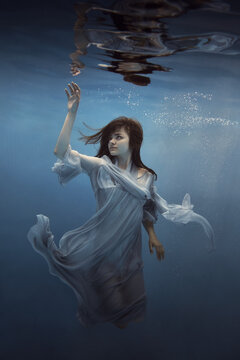   Portrait Of A Girl In A Blue Dress Under Water      