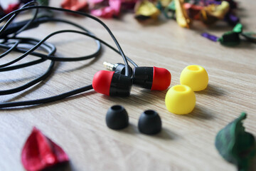 black earphones with red and yellow erasers and floral decoration