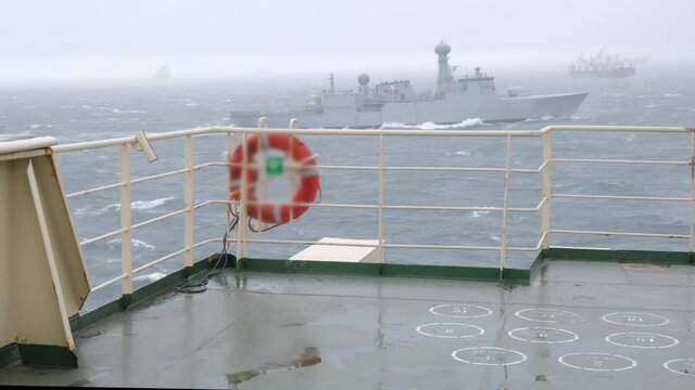 large white warship astern Natig Aliev tanker during heavy storm on Danish port of Skagen raid against grey waving sea