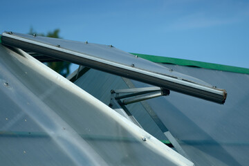 The window in the greenhouse has an automatic drive to maintain the set air temperature.