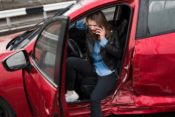 Fototapeta na wymiar Young pretty scared woman in the car. Woman calls to a rescue service