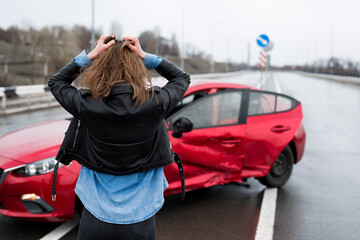 Woman stands near a broken car after an accident. call for help. car insurance