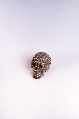 Vertical shot of a decorative skull made of smaller skulls on a white background