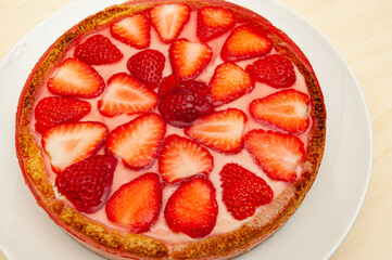Delicious homemade strawberry tart. Isolated on wooden background. Top view. Close-up. Horizontal shot.