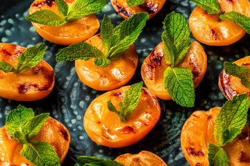 Homemade grilled peaches with mint, top view. Food recipe background. Close up