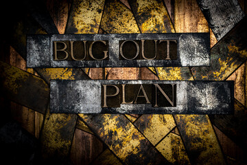 Bug Out Plan text formed with real authentic typeset letters on vintage textured silver grunge copper and gold background