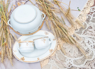 Antique fayence plate and pair of mugs with the same yellow pattern - countryside porcelain objects with wheat cereal on lace tableclothes