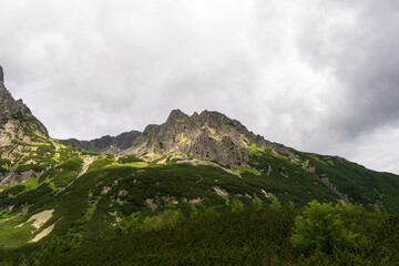 Fototapeta premium Mountain landscape with rocks and creeping fog. High peaks in the clouds, cold weather. Tourism in the mountains, tatry slovakia jahnaci stit