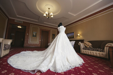 Chic wedding dress and veil on a mannequin in the bride 's gathering room