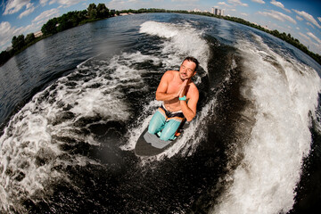 Naklejka premium high angle view of man with his eyes closed and praying pose on surfboard on the water