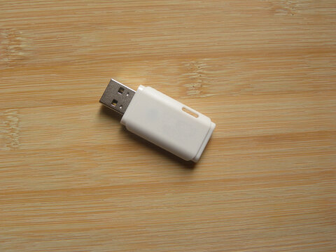 White Color USB Flash Pen Drive Kept On Wooden Table