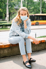 Portrait of young woman wearing antibacterial mask in a city.