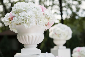 White and pink flowers in vases at the wedding ceremony