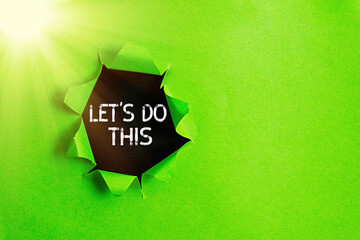 Writing note showing Let S Do This. Business concept for the act to agree on doing something or would like to do it Rolled ripped torn cardboard above a wooden classic table