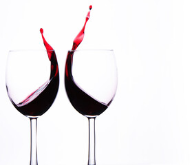 Two Crystal Wine Glasses with Red Wine and Splashes.