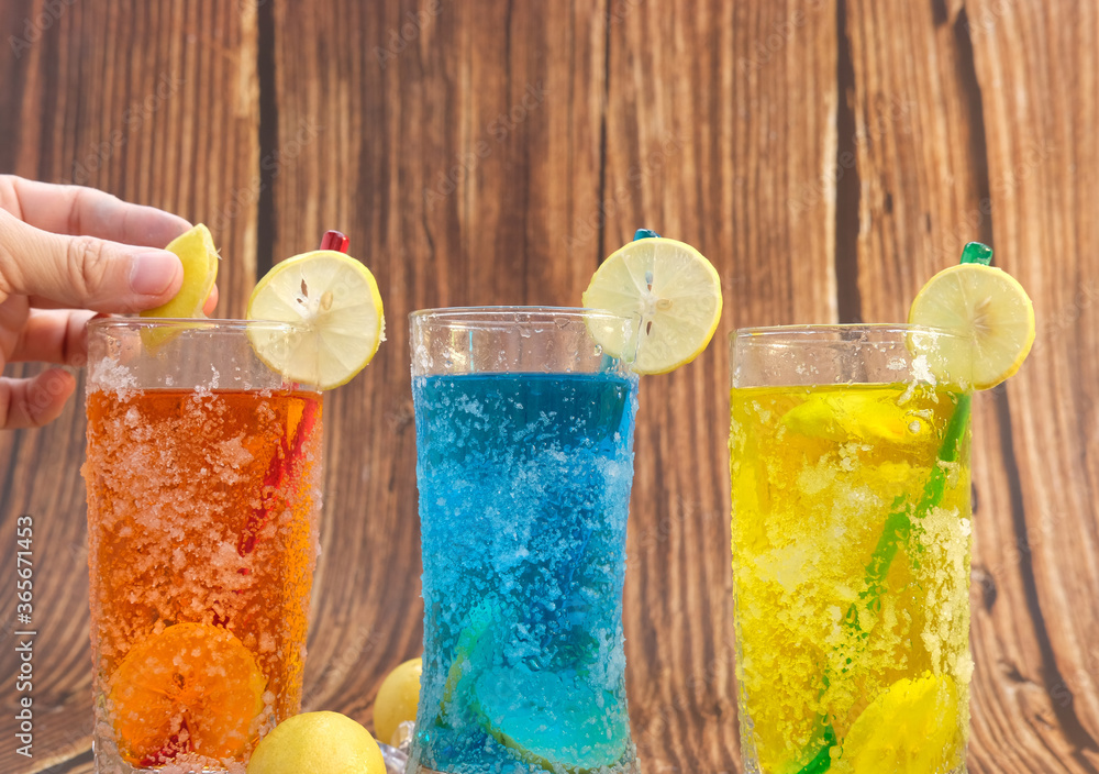 Wall mural Colorful cocktail in glasses on wood table