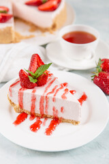 Sweet breakfast, tea and delicious cheesecake with fresh strawberries and mint, homemade recipe without baking, on a blue stone table. Copy space.