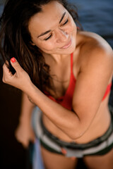 high angle view of woman with brown hair which correct her hair by hand