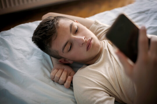  young boy in bed with a smartphone