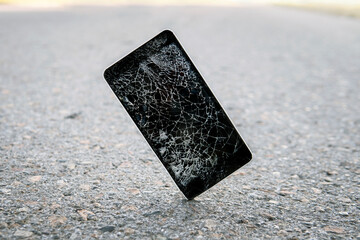 Phone while falling on the road. Mobile phone cracks on impact on concrete. Modern smartphone with...