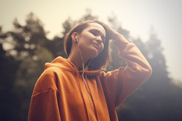 Hipster attractive girl in park using earphones