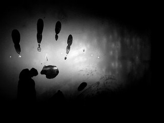 Abstraction, handprint on cold or misted glass, in the dark. Mysterious fingerprint with the effect of mystery and mysticism. Cover for a detective story or unsolved mystery.