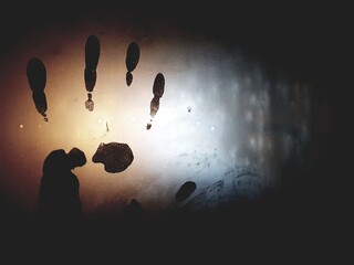 Abstraction, handprint on cold or misted glass, in the dark. Mysterious fingerprint with the effect...