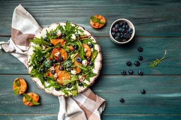 Vibrant grilled peach salad with blueberries and creamy goat cheese, Healthy vegan salad, place for text, top view