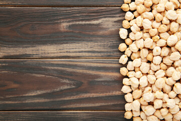 Dry raw organic chickpeas on brown wooden background.