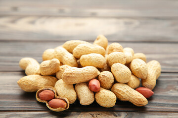 Fried peanuts on a brown wooden background.