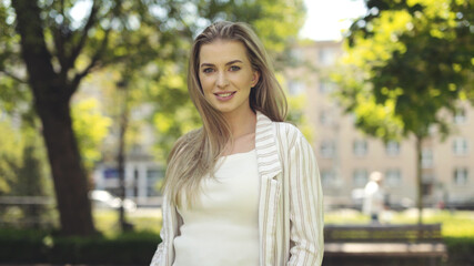 Portrait of beautiful young blonde woman in a city.