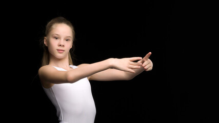 Girl gymnast on a black background.The concept of sport, beauty, people.