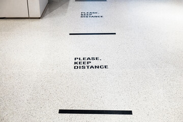 Please keep distance  sign on the floor inside department store for people to wait in line. New...
