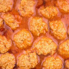 Culinary background - meatballs in red tomato sauce, top view, close-up