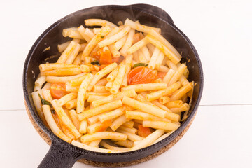 Fast and easy italian pasta arrabiata in a frying pan, close-up