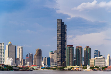 Fototapeta na wymiar cityscape of Bangkok city skyline with river and blue sky background, Bangkok city is modern metropolis of Thailand and favorite of tourists