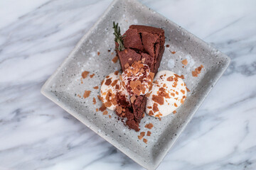 Close up Delicious homemade dessert flourless chocolate cake with cream on top sliced into piece.