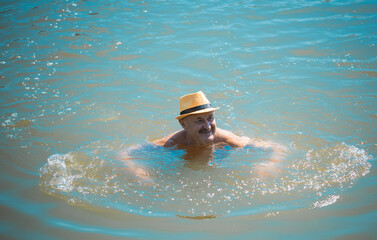 Happy senior man swiming at water, at nature and rest, lifestyle of people on retired