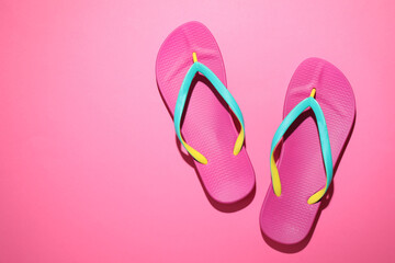 Obraz na płótnie Canvas Pair of stylish flip flops on pink background, top view with space for text. Beach objects