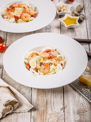 Caesar salad with fried shrimp, quail eggs and parmesan cheese on a white plate. Mediterranean Kitchen. Vertical shot