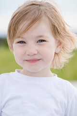 Joyful child girl in white tshirt on summer day.