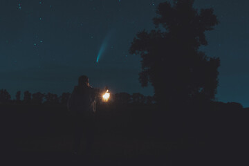 girl with a lantern in her hand at night looking at a comet Neowise © drakuliren
