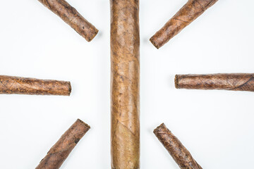 The sun laid out of twisted cigars on white background.