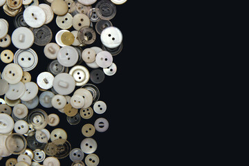 Sewing buttons background. White sewing buttons texture and patterns on black background