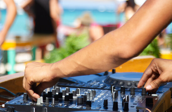 Hand of a sound technician adjusting the sound table in a beach party