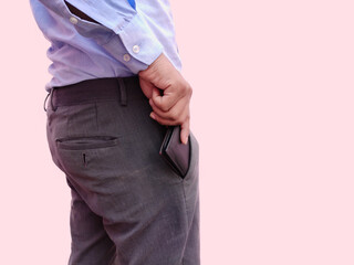 Close up man keeping his wallet money in the front pocket of pants. Background wallpaper white