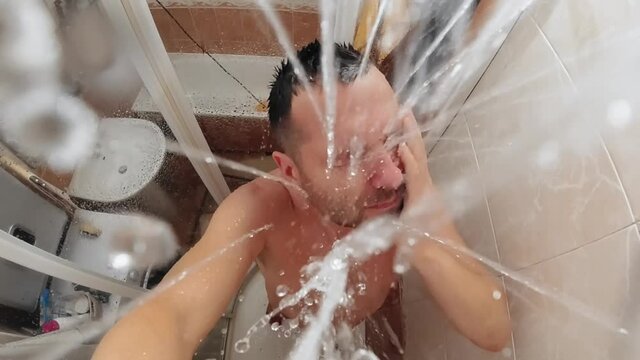Slow motion shot of a man taking a shower. View from above.