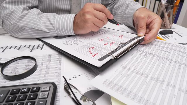 Business analysis and accounting concept - businessman working with document, spreadsheet, using calculator, tablet pc. Office desk closeup. 

